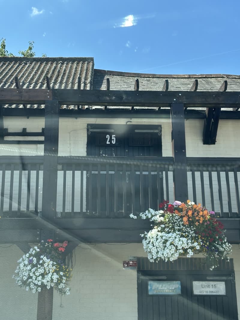 Black-and-white timbered building with hanging flower baskets under a blue sky
